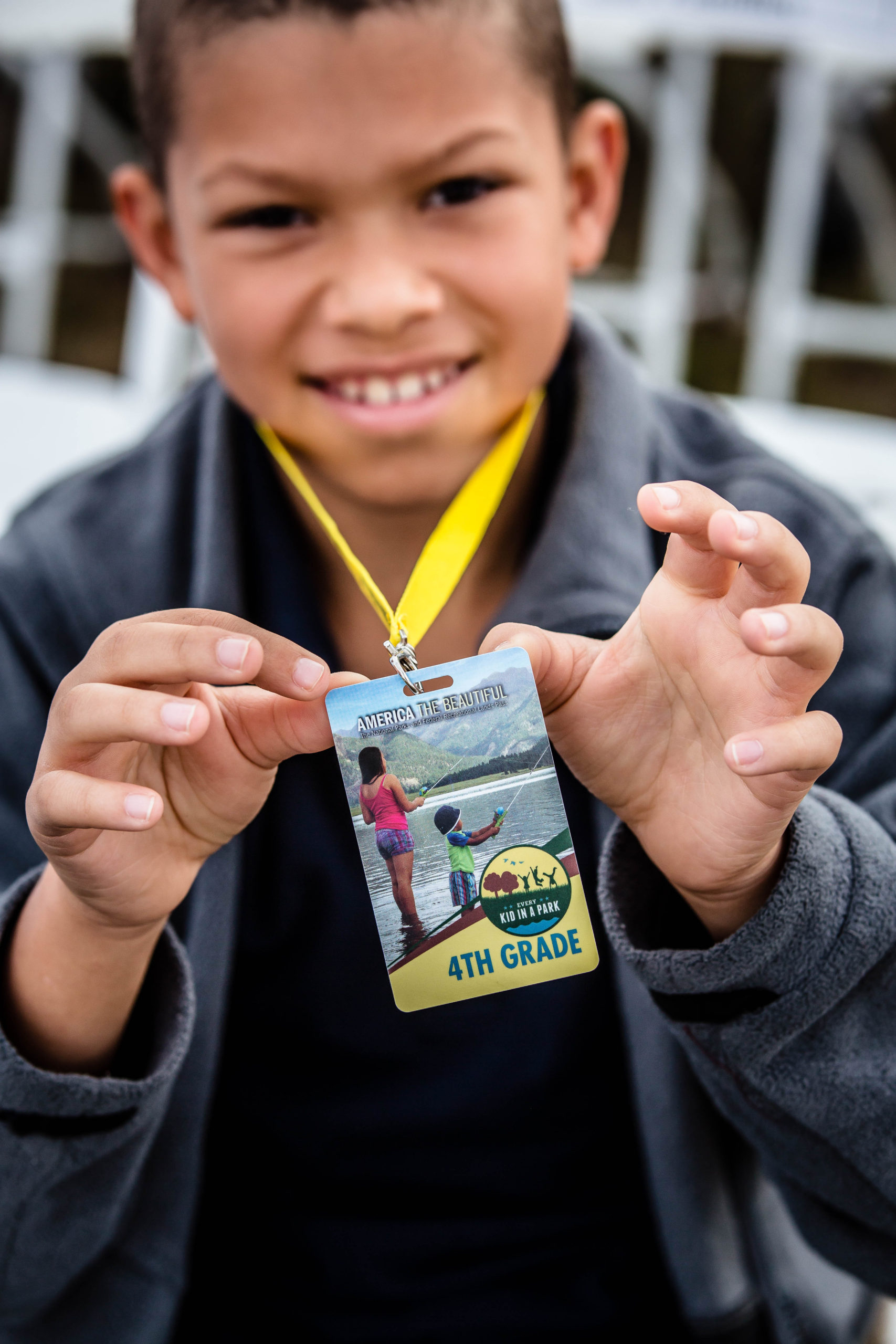 A fourth grade boy holds up his visitor pass at Wright Brothers National Memorial.