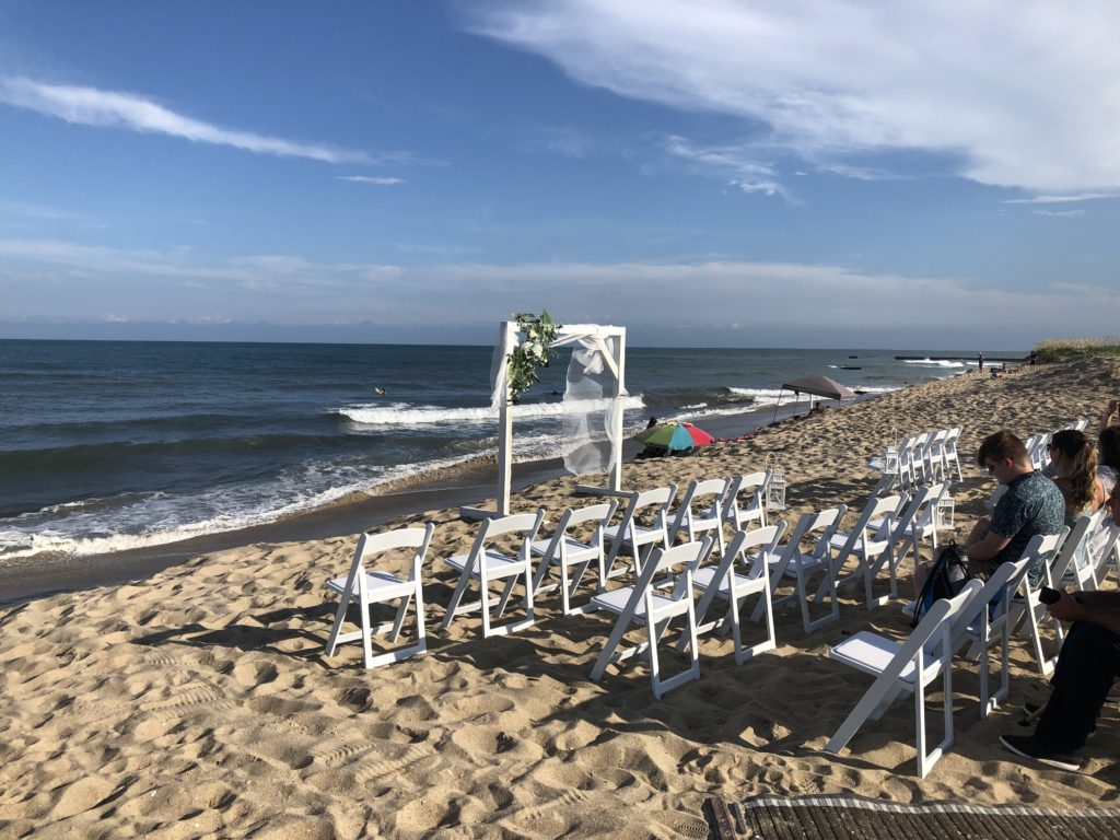 A wedding arch and chairs set up on the beach at Cape Hatteras National Seashore. 