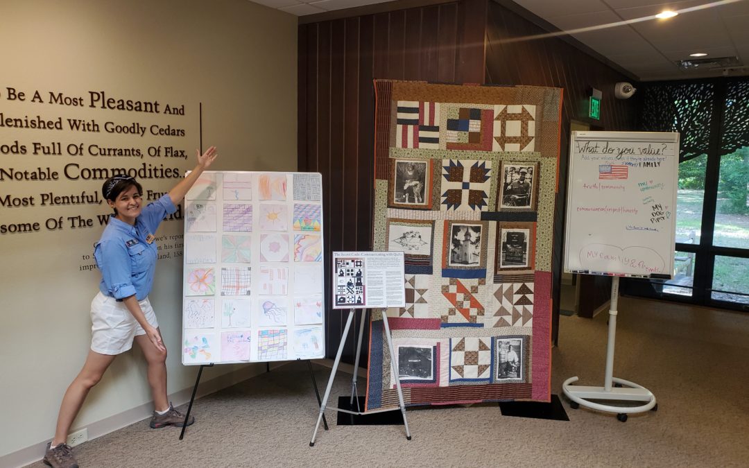Latino Heritage Internship Program Intern Isabel Gonzalez stands next to a Freedmen's Colony display inside the Visitor Center at Fort Raleigh National Historic Site.