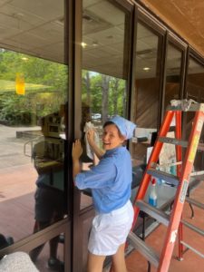 Latino Heritage Internship Program Intern Isabel Gonzalez washes a window outside of the Visitor Center at Fort Raleigh National Historic Site.