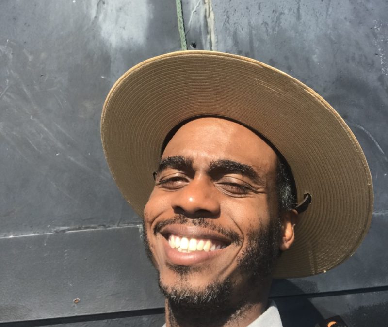 Seasonal Interpretive Ranger Adonis Osekre smiles as he takes a selfie at Wright Brothers National Memorial.