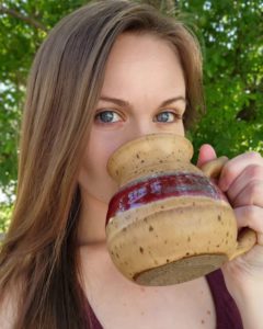 Adele Valerius, founder of Roasts for Coasts Coffee Co., with a mug of coffee.