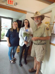 Jack Currie, Mona's husband and fellow volunteer, presenting a bag of produce from the Education Garden at Fort Raleigh National Historic Site to Roanoke Island Food Pantry volunteers. 