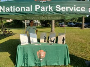 Latino Heritage Internship Program intern Pia Cano working at the National Park Service table during the 2023 Juneteenth celebration at the Cookhouse Museum on Roanoke Island.