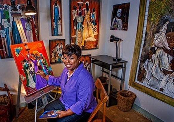 Sonja Griffin Evans in her studio, surrounded by her artwork.